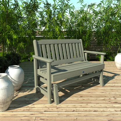 4ft light green Blue Ridge glider bench on wooden patio with plants in background 