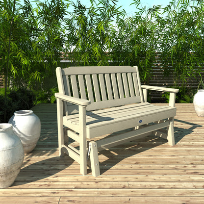 4ft Whitewash Blue Ridge glider bench on wooden patio with plants in background 