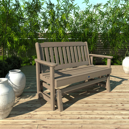 4ft light brown Blue Ridge glider bench on wooden patio with plants in background 