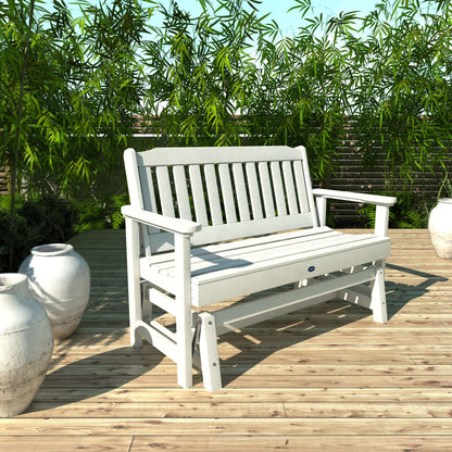 4ft White Blue Ridge glider bench on wooden patio with plants in background 