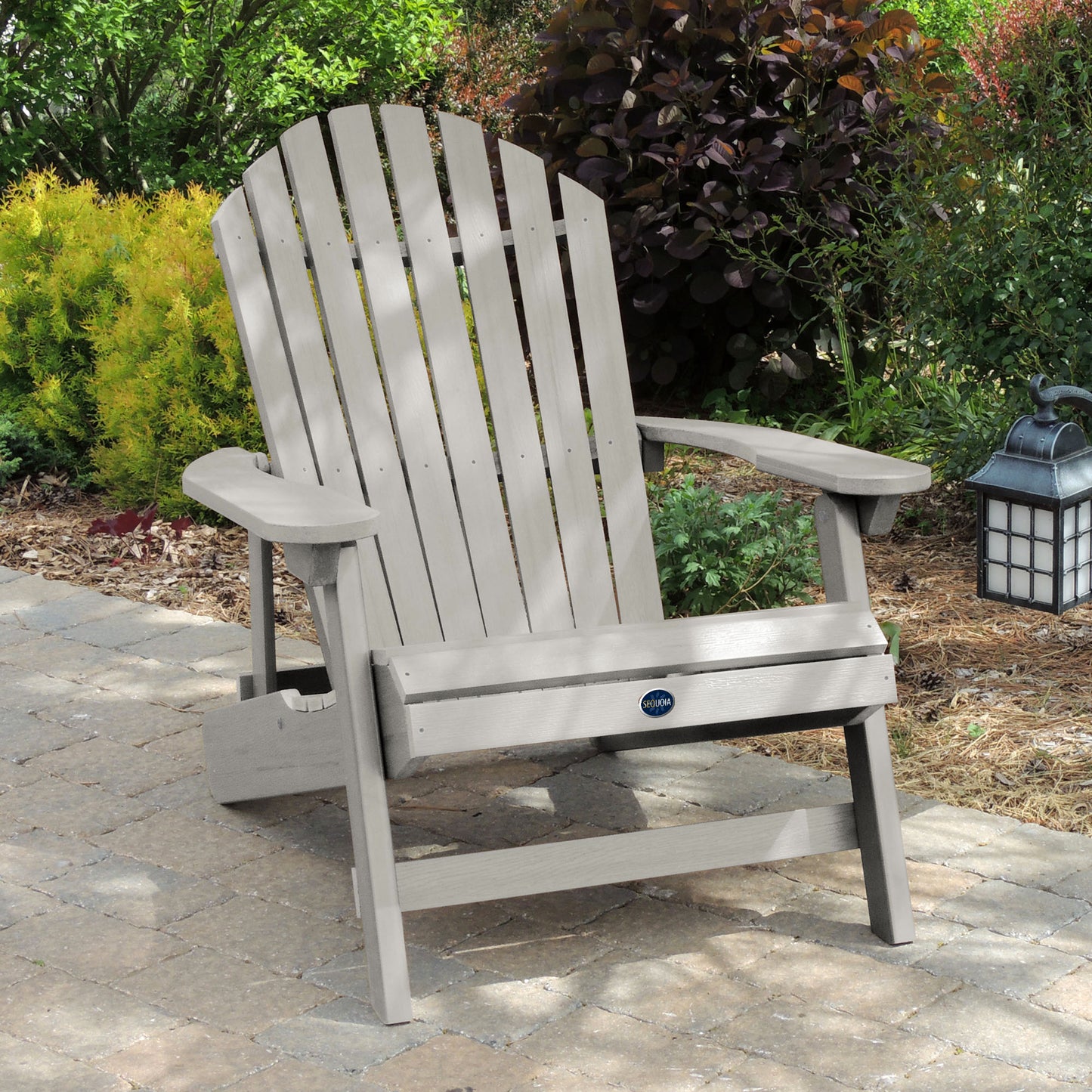 Light gray Horizon King-sized Adirondack chair on stone with trees in background