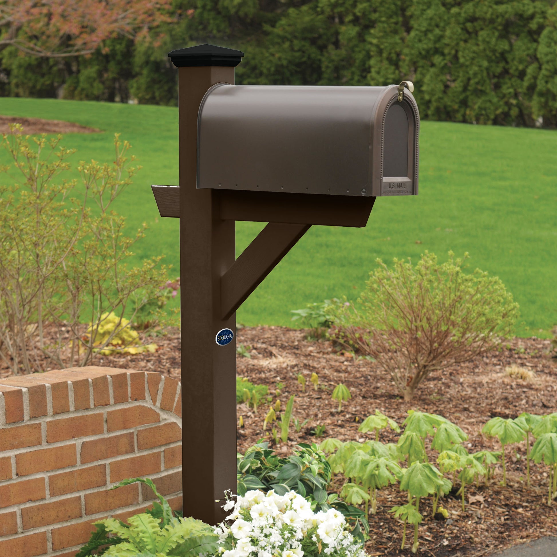 Brown St. Clair Mailbox post standing in flower bed