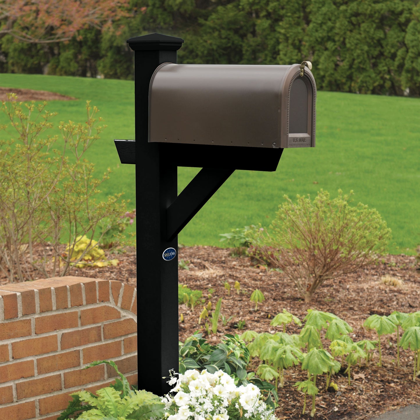 Black St. Clair Mailbox post standing in flower bed