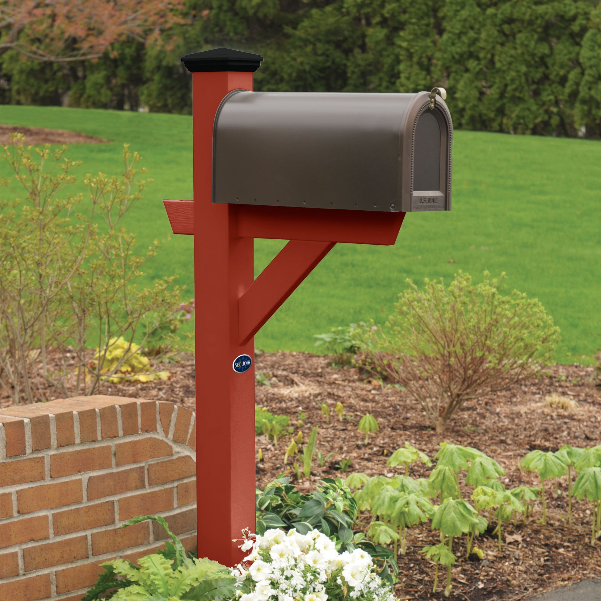 Red St. Clair Mailbox post standing in flower bed