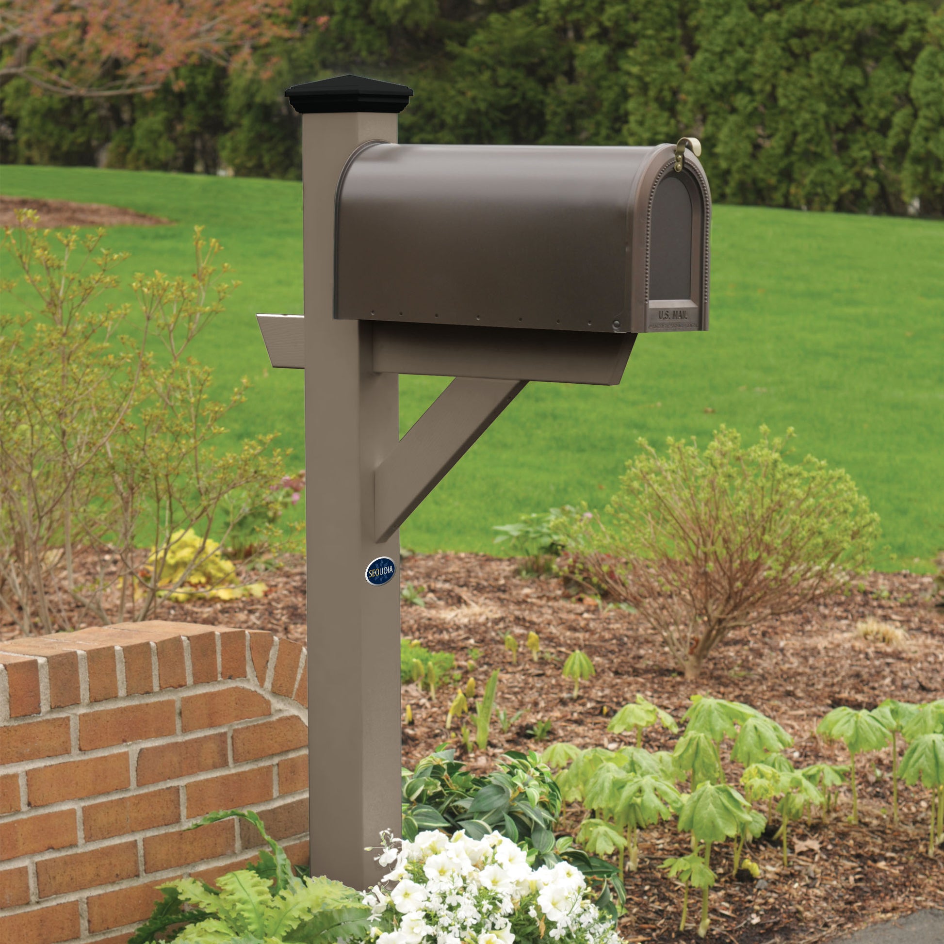 Light brown St. Clair Mailbox post standing in flower bed