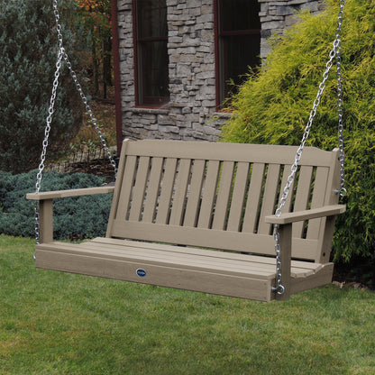 Light brown 5ft Blue Ridge porch swing with stone house in background