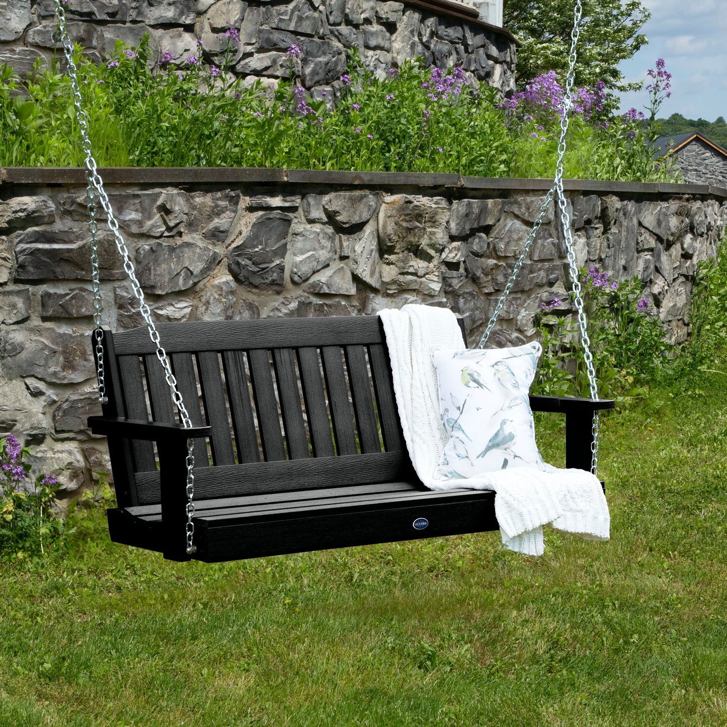 Black 4ft Blue Ridge porch swing with blanket and pillow and stone wall in background