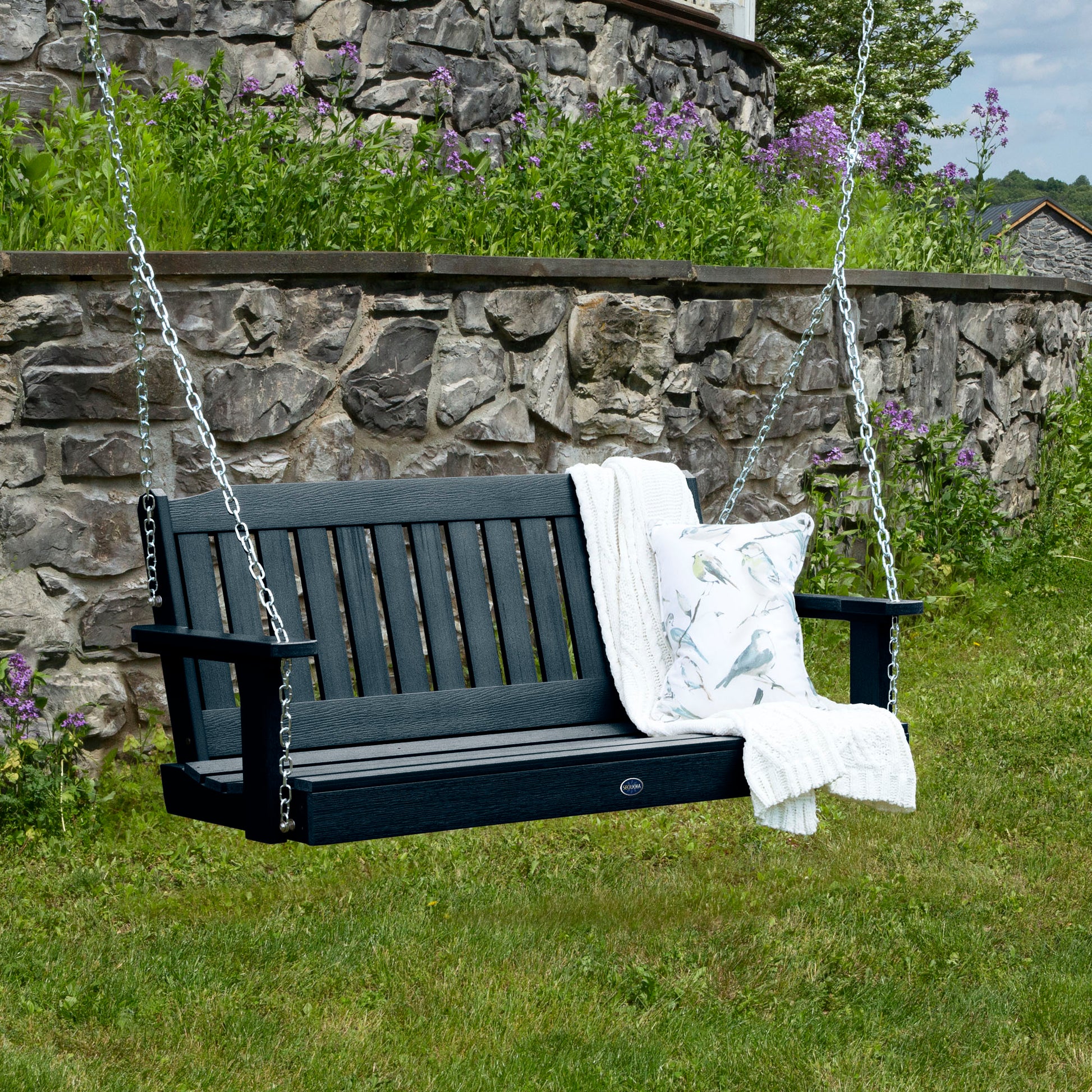 Dark Blue 4ft Blue Ridge porch swing with blanket and pillow and stone wall in background