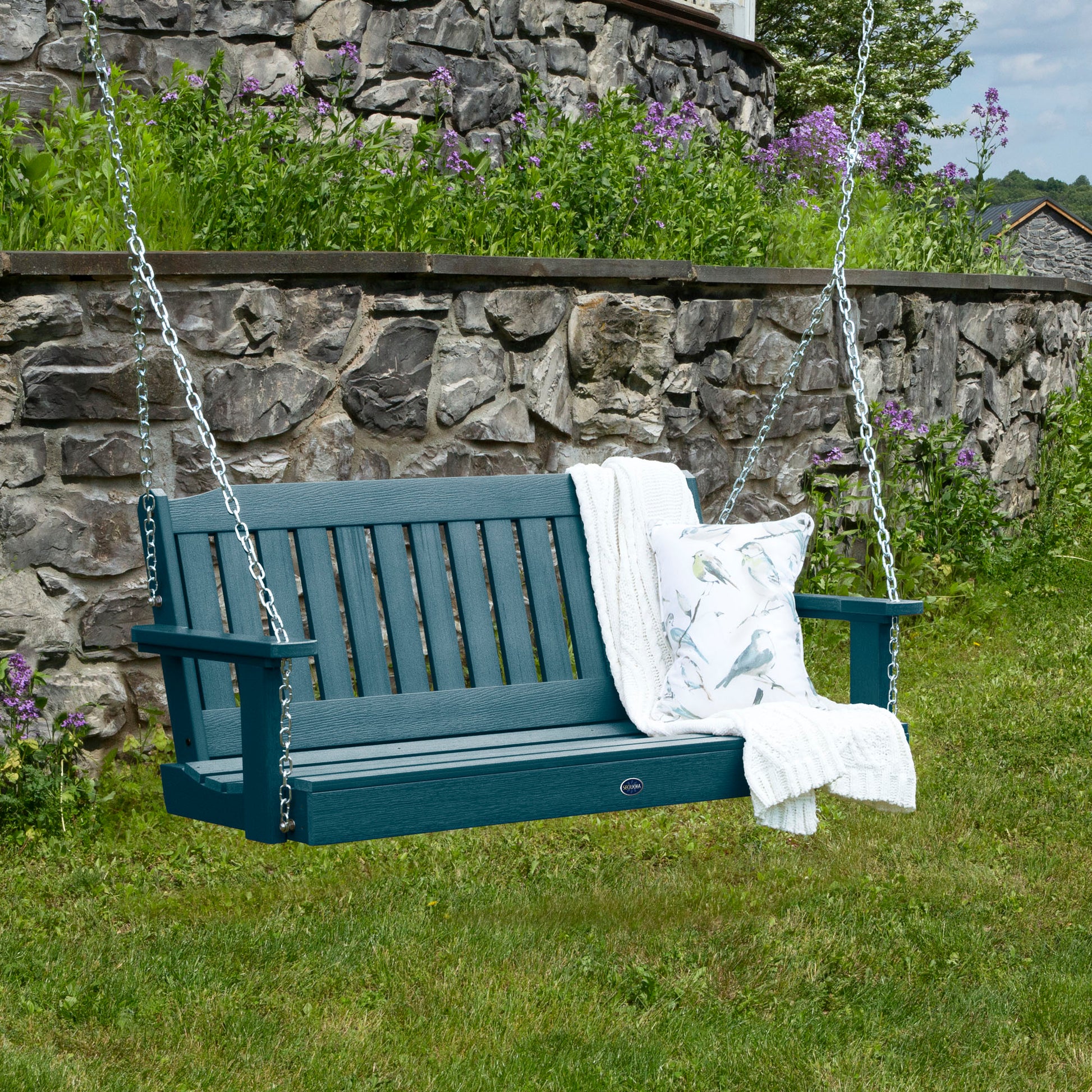 Light blue 4ft Blue Ridge porch swing with blanket and pillow and stone wall in background