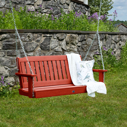 Red 4ft Blue Ridge porch swing with blanket and pillow and stone wall in background