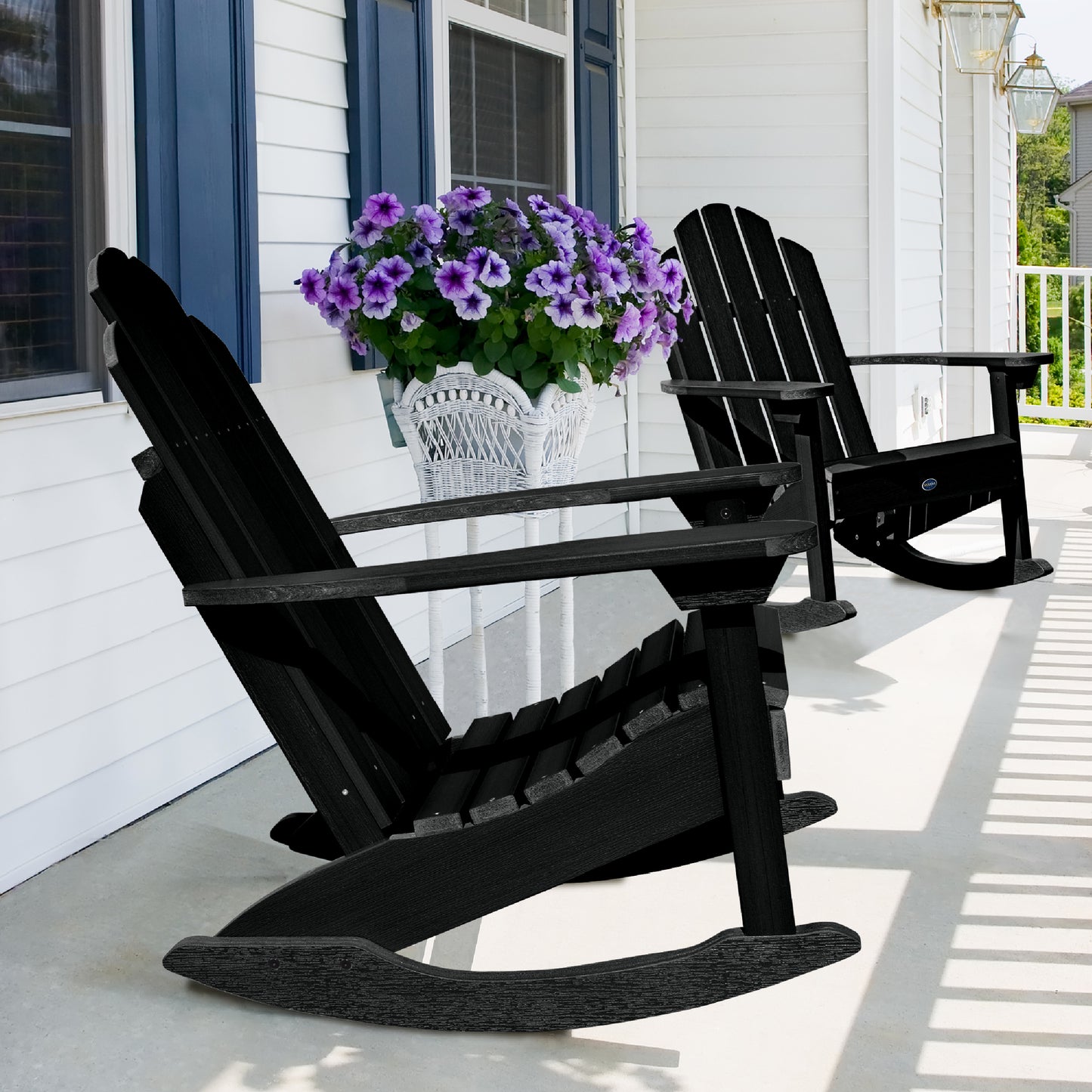 Two Black Lighthouse Adirondack rocking chairs on front porch with flowers