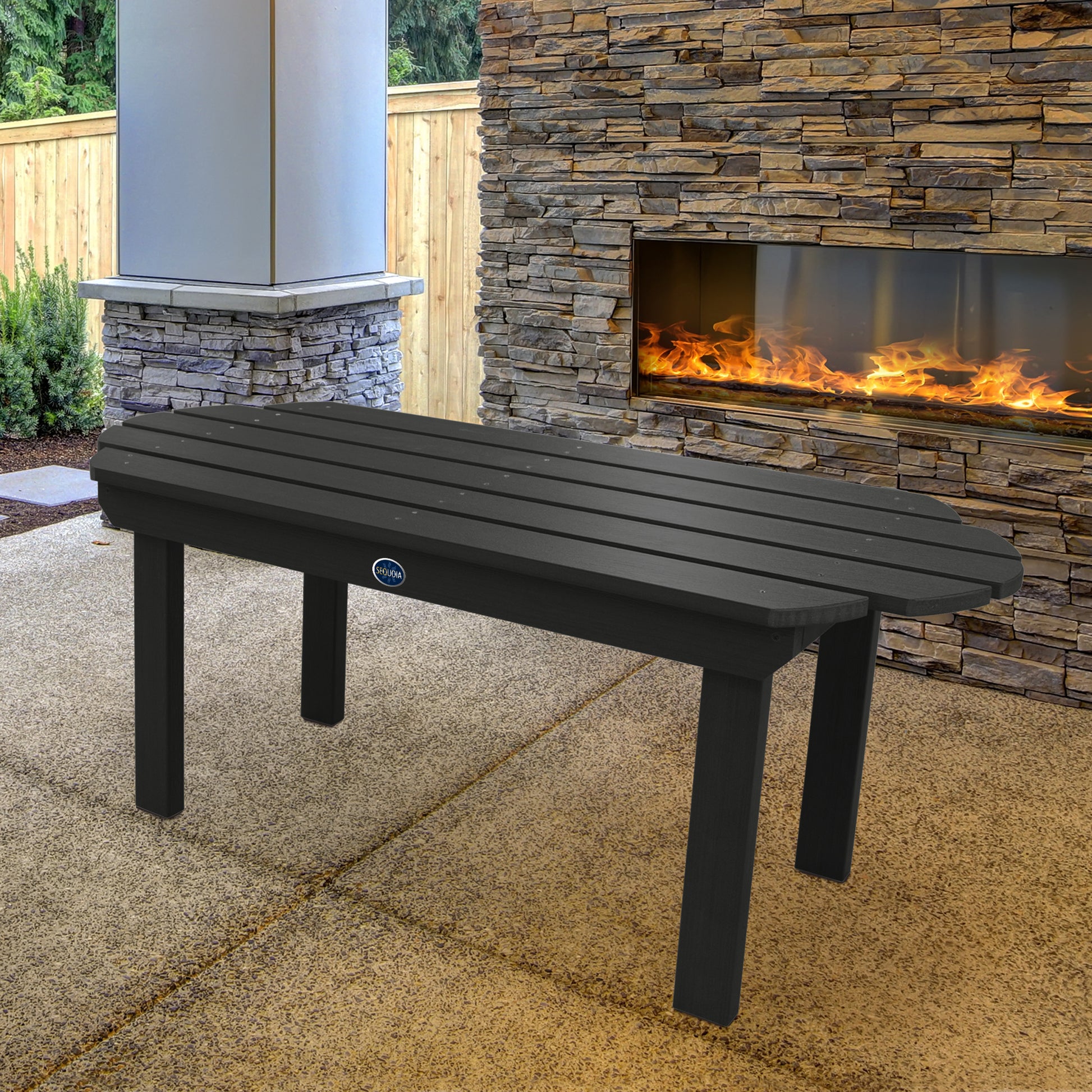 Black Lighthouse conversation table in front of outdoor fireplace 