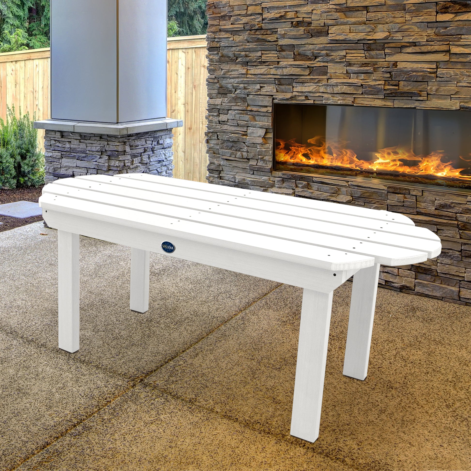 White Lighthouse conversation table in front of outdoor fireplace 