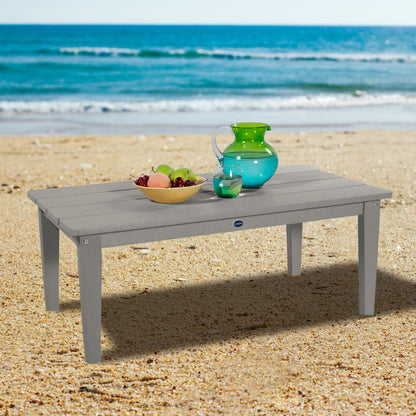 Gray Sunrise Coast conversation table on beach with water pitcher and fruit