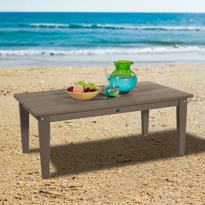 Tan Sunrise Coast conversation table on beach with water pitcher and fruit