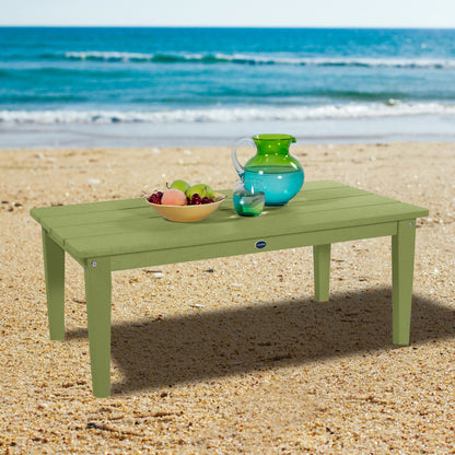 Green Sunrise Coast conversation table on beach with water pitcher and fruit